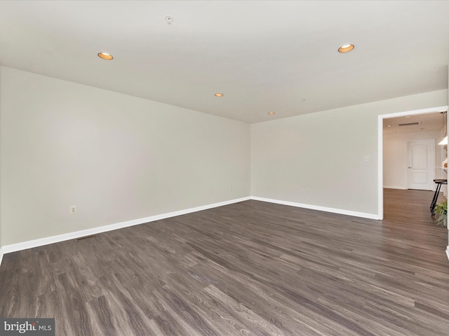 unfurnished room with visible vents, baseboards, dark wood-type flooring, and recessed lighting