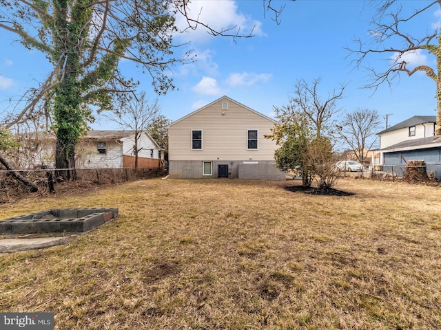 rear view of property featuring a yard, cooling unit, and fence