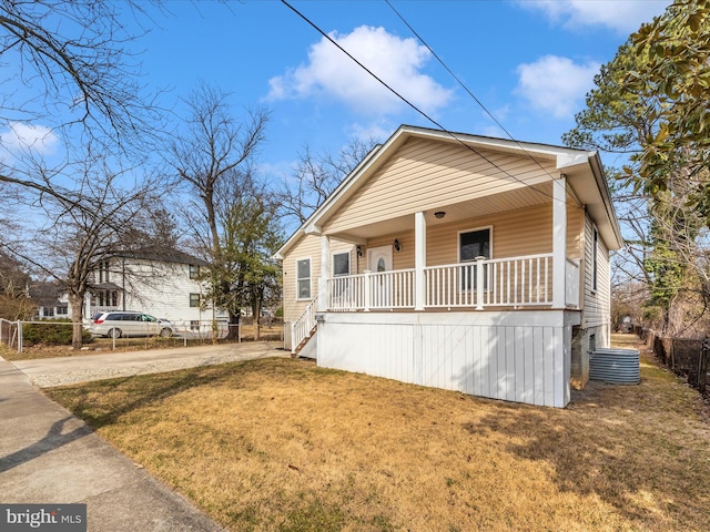 view of front of property with a porch, a front yard, concrete driveway, and fence