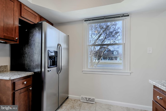 kitchen with visible vents, baseboards, light countertops, light tile patterned floors, and stainless steel refrigerator with ice dispenser