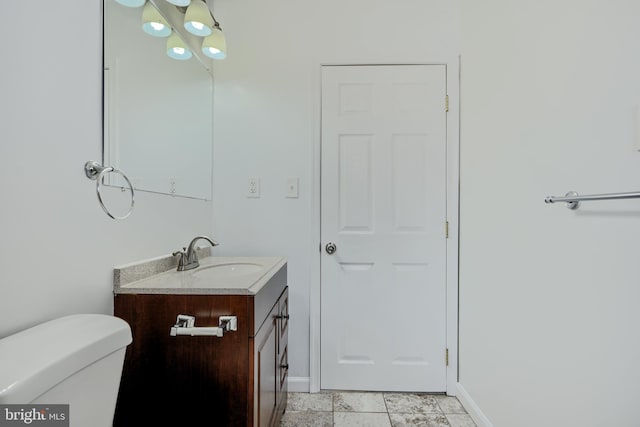 bathroom featuring baseboards, toilet, and vanity