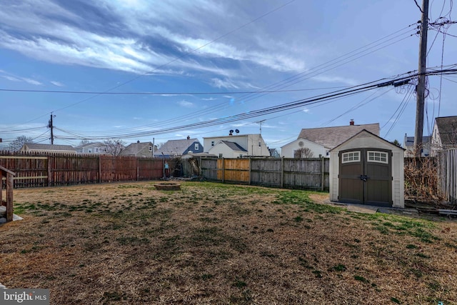 view of yard featuring a storage shed, a fenced backyard, and an outdoor structure