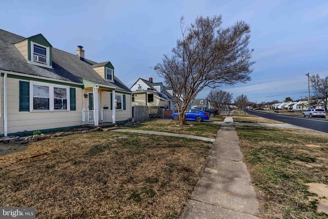 view of home's exterior featuring a lawn, a chimney, roof with shingles, and fence