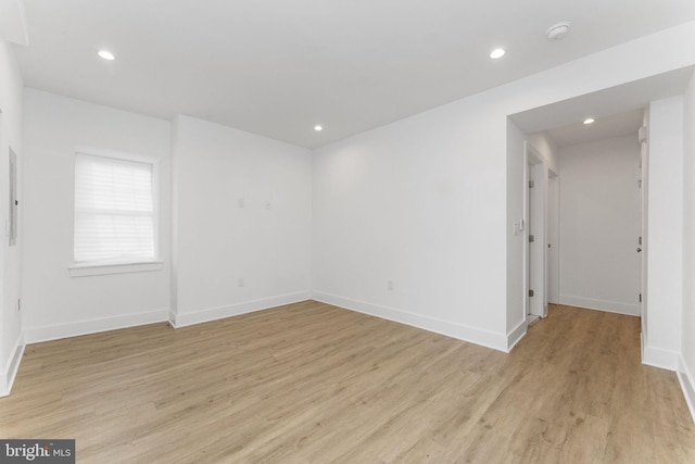 spare room with light wood-type flooring, baseboards, and recessed lighting