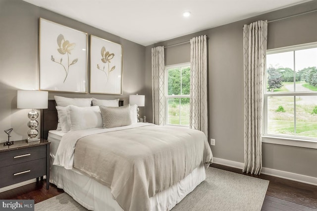 bedroom with baseboards and dark wood-type flooring