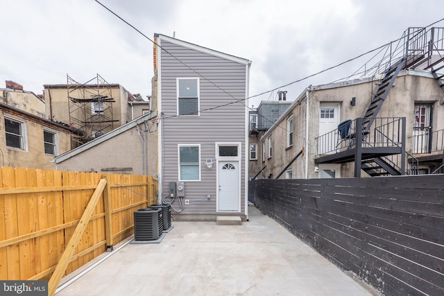 back of house featuring central AC, a patio area, and a fenced backyard