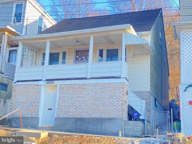 view of side of home featuring roof with shingles and brick siding