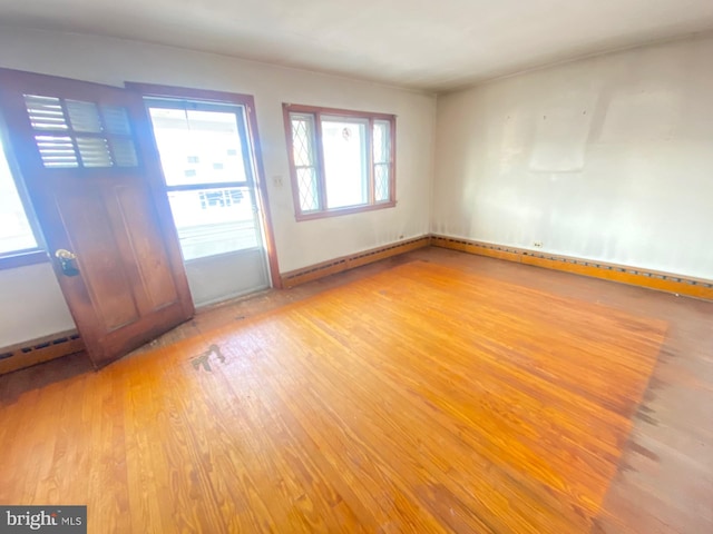 interior space featuring a baseboard heating unit and wood finished floors