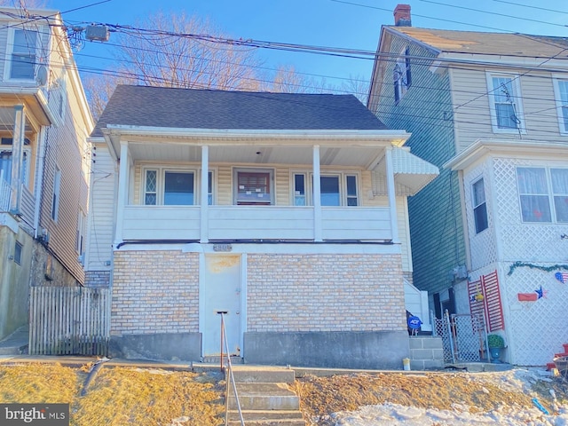 townhome / multi-family property with brick siding, roof with shingles, and fence