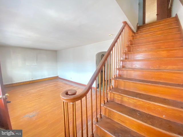 stairs with baseboards and wood finished floors