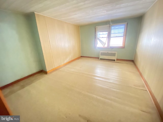 empty room with radiator and baseboards