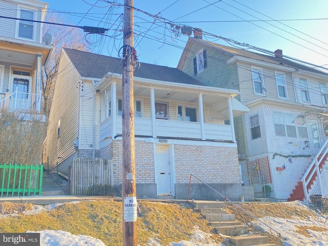 view of front facade with brick siding and fence