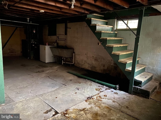 basement featuring washer / dryer, a sink, and stairway