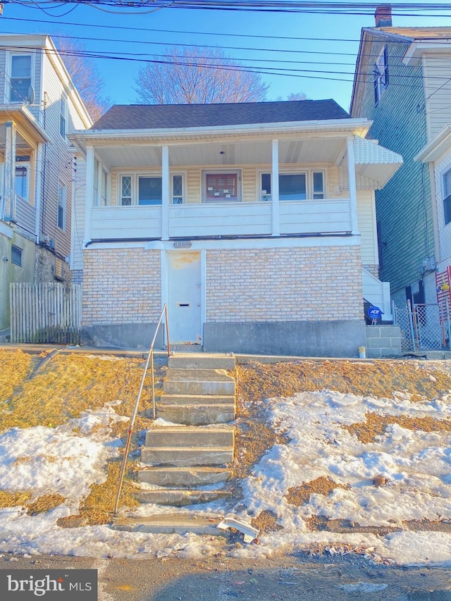 view of front of home featuring brick siding and fence