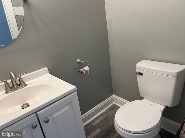 bathroom featuring wood finished floors, vanity, toilet, and baseboards