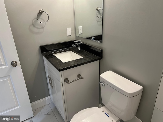 bathroom with marble finish floor, baseboards, vanity, and toilet