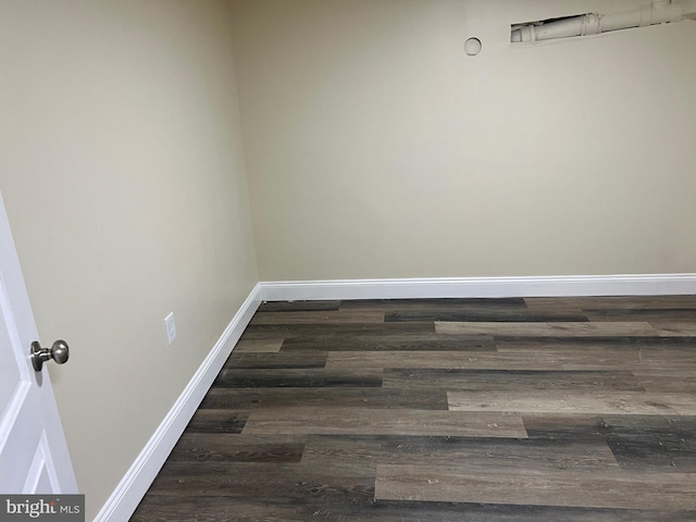 spare room with wood finished floors and baseboards