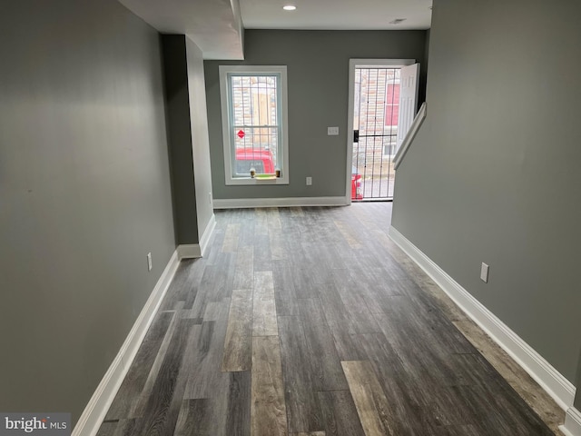 interior space featuring baseboards and dark wood-type flooring