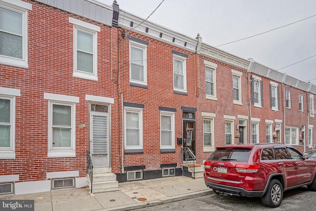 townhome / multi-family property featuring brick siding and entry steps