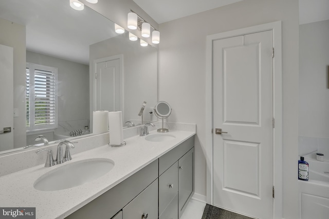 bathroom featuring a bathtub, a sink, and double vanity