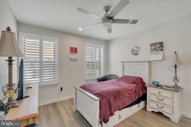 bedroom with ceiling fan, light wood finished floors, and baseboards