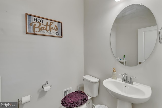 bathroom featuring toilet, visible vents, and a sink