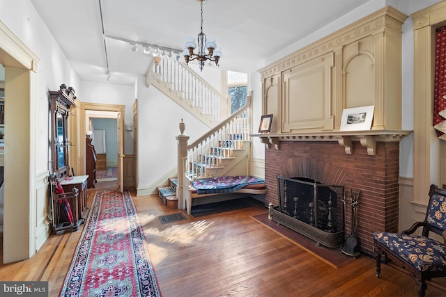 entryway with stairs, track lighting, a chandelier, and light wood-style floors