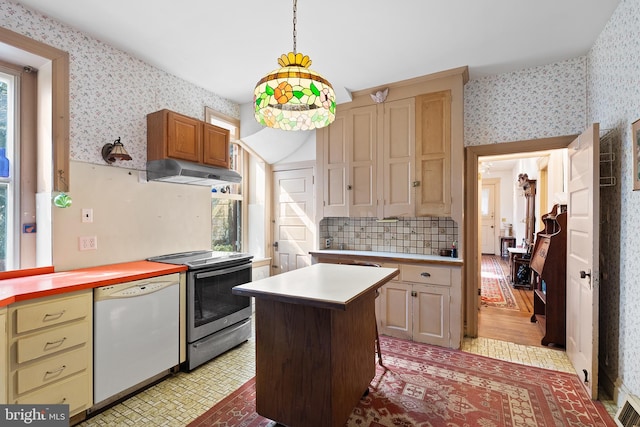 kitchen with under cabinet range hood, light countertops, stainless steel electric range, dishwasher, and wallpapered walls