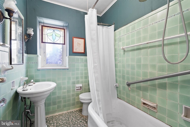 bathroom with shower / tub combo, toilet, a sink, tile patterned flooring, and tile walls