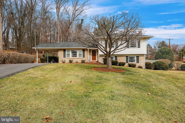 split level home with brick siding, aphalt driveway, an attached carport, and a front yard