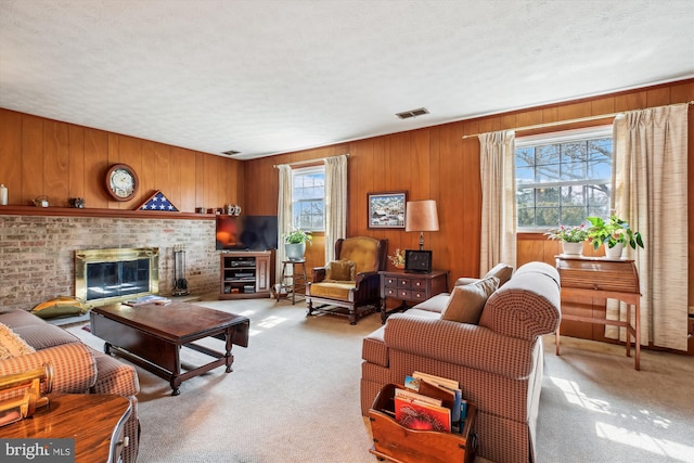 living area with visible vents, a textured ceiling, a fireplace, and carpet flooring