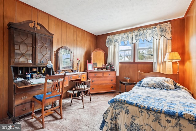 bedroom with wooden walls, a textured ceiling, crown molding, and carpet