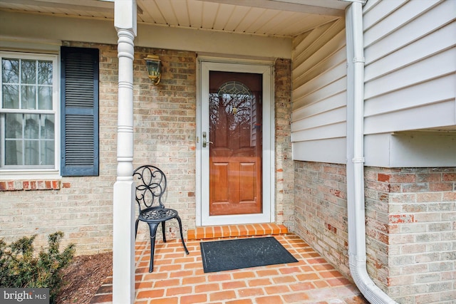 view of exterior entry with brick siding