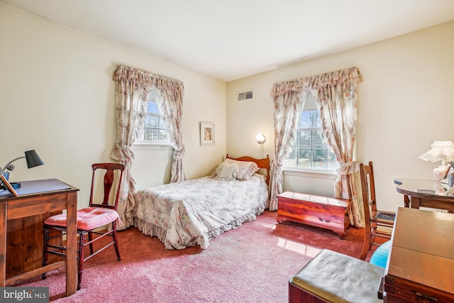 carpeted bedroom featuring multiple windows and visible vents