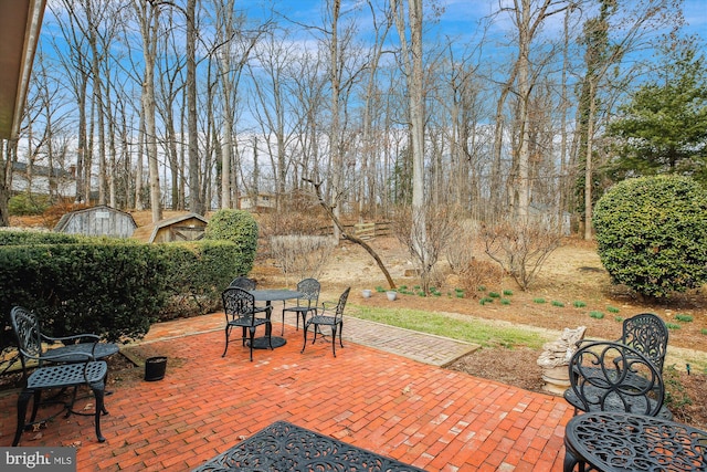 view of patio featuring an outbuilding and a storage shed