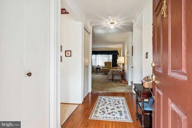 foyer entrance featuring wood finished floors and ornamental molding