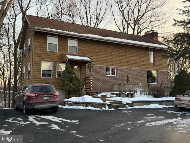 view of front of home with brick siding and a chimney