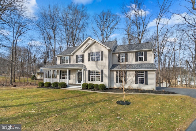 view of front of home with a porch, a front yard, a shingled roof, and aphalt driveway