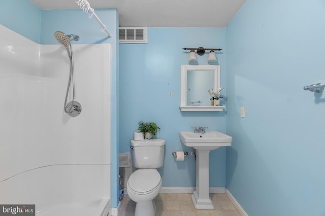 bathroom featuring toilet, walk in shower, visible vents, and baseboards