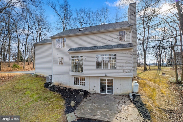 back of house with a yard, central AC unit, a chimney, and a patio area