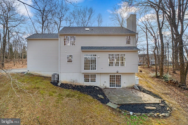 rear view of house with a patio area, a chimney, and central AC unit