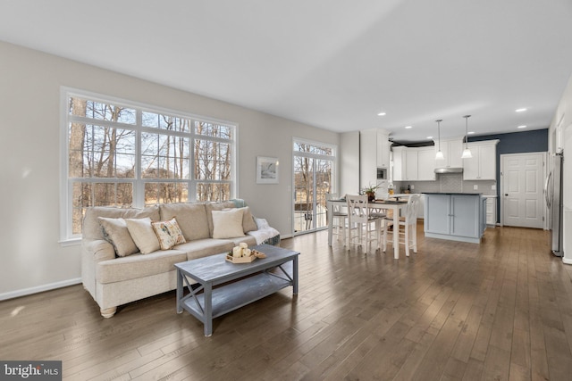 living area with recessed lighting, dark wood finished floors, and baseboards