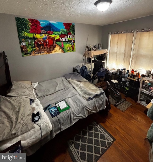 bedroom with wood finished floors and a textured ceiling