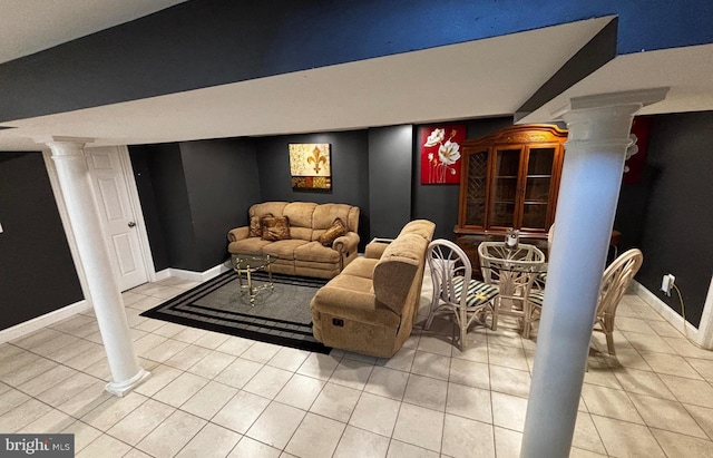 living area with decorative columns, baseboards, and light tile patterned floors