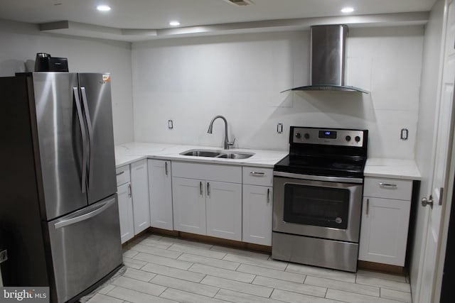 kitchen featuring a sink, stainless steel appliances, light stone counters, and wall chimney exhaust hood