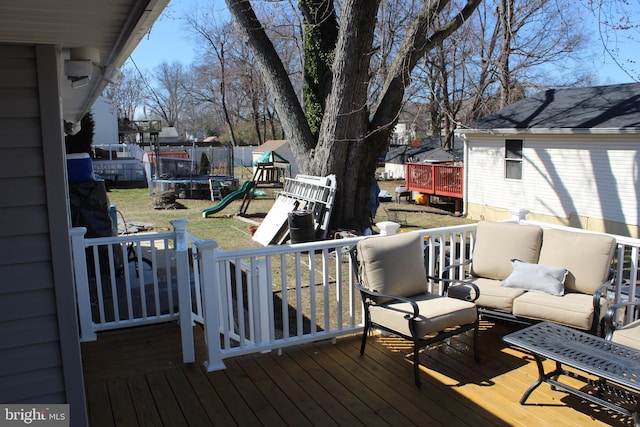 deck with outdoor lounge area, a playground, a trampoline, and fence