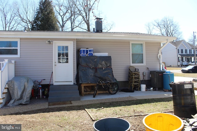 rear view of house with a chimney and entry steps