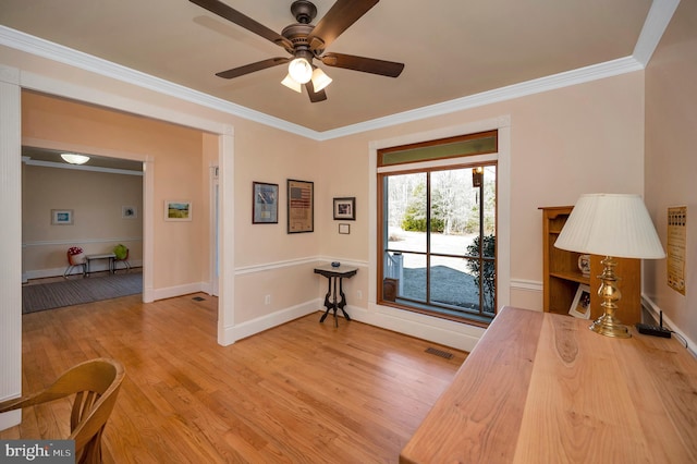 home office with ornamental molding, wood finished floors, visible vents, and baseboards