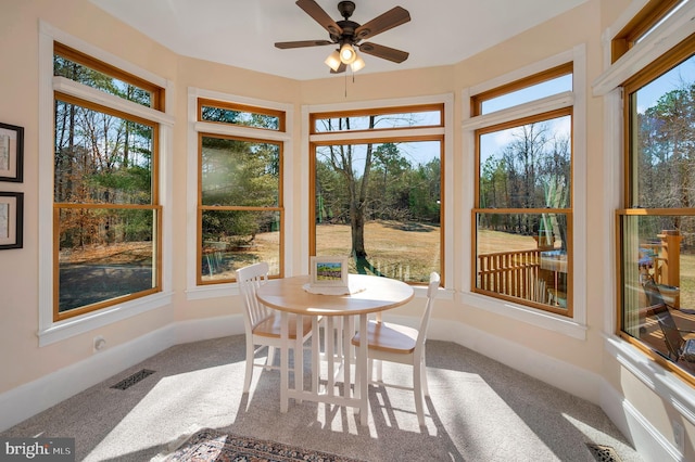 sunroom with a ceiling fan, a wealth of natural light, and visible vents