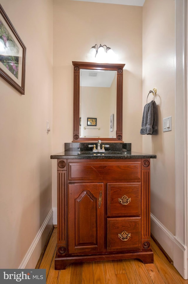 bathroom featuring wood finished floors, vanity, and baseboards